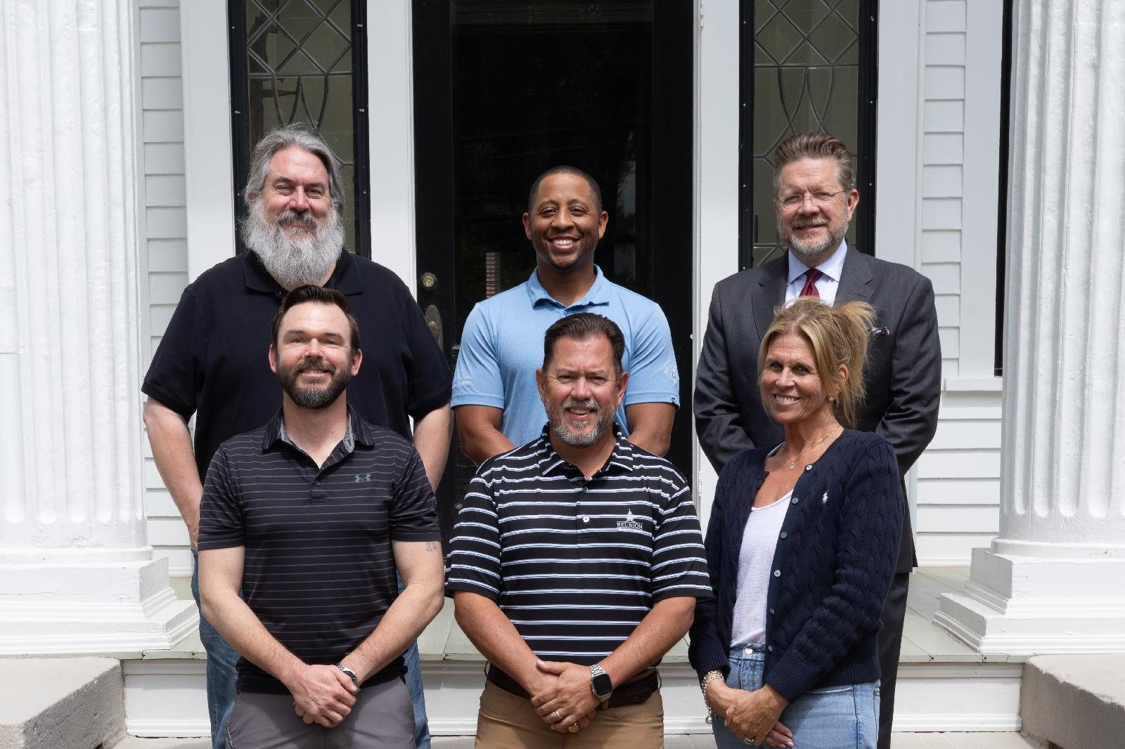 Members of the Braselton Police Foundation board of directors standing on the steps of a white columned building.